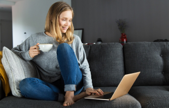 Žena sedící na gauči s počítačem